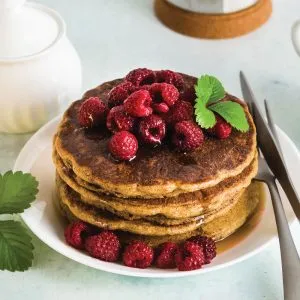 Stack of buckwheat pancakes made with Organic Buckwheat Pancake & Waffle Mix – topped with fresh raspberries and mint