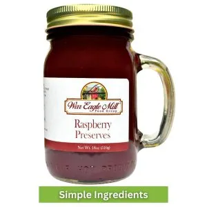 Jar of War Eagle Mill Raspberry Preserves in an 18 oz glass mug