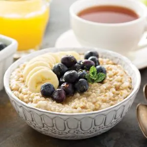 Cooked steel cut oats topped with banana and blueberries.