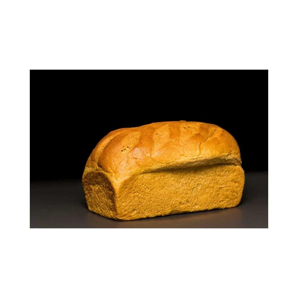 Freshly baked whole wheat honey bread loaf with a golden crust, made with organic whole wheat flour and natural honey.